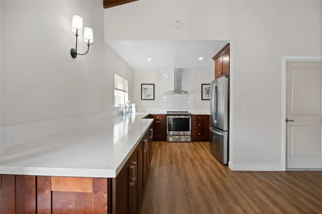 a living room with furniture and a view of kitchen