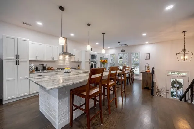 a kitchen with kitchen island a sink stove a center island with wooden floor