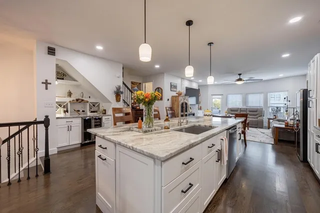 a kitchen with granite countertop a sink a stove and cabinets
