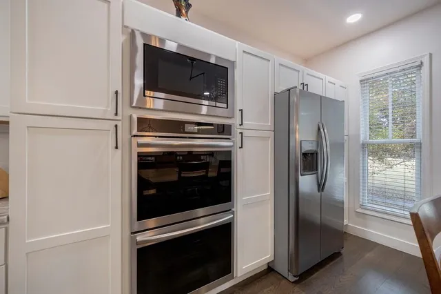 a kitchen with stainless steel appliances granite countertop wooden floors and sink
