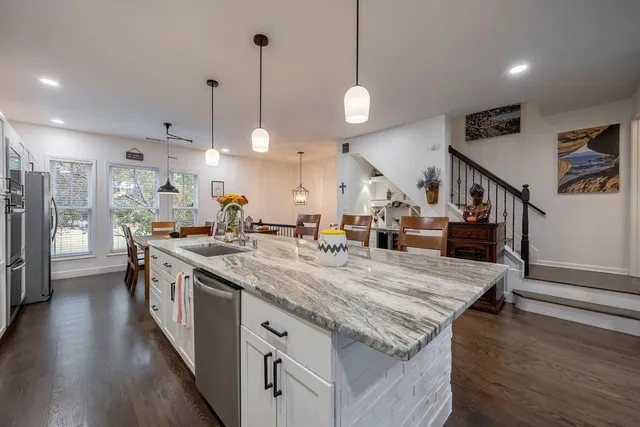 a kitchen with kitchen island a sink stove and cabinets