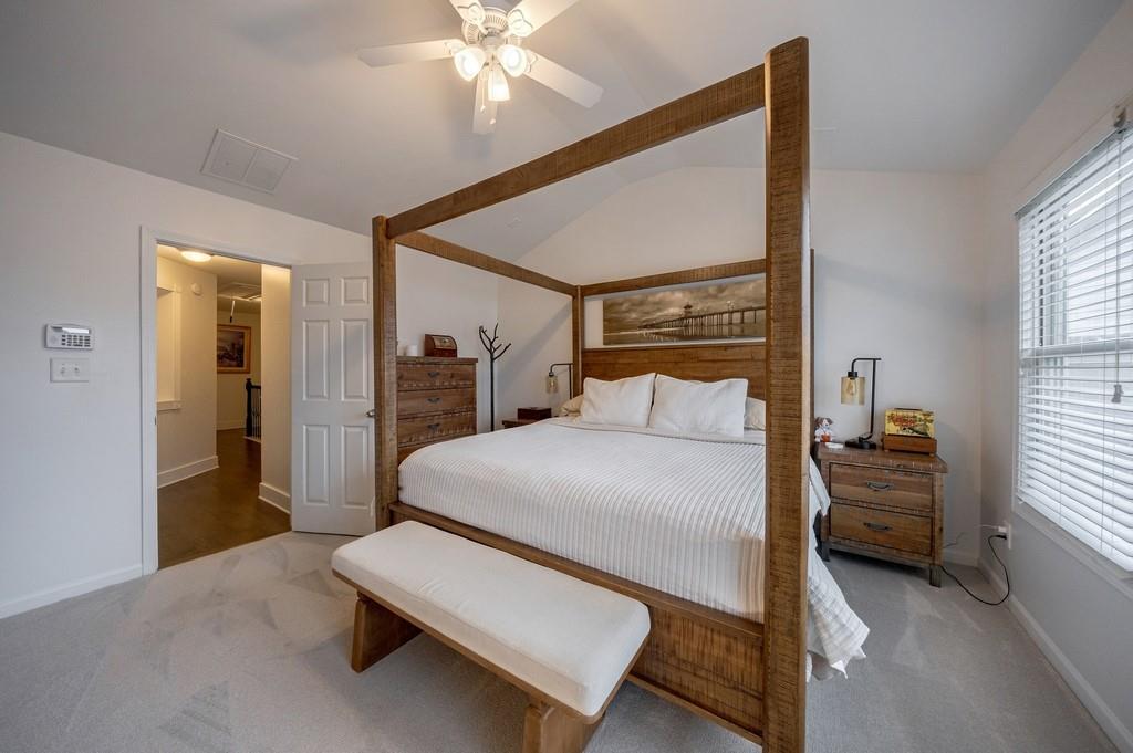 3908 Charleston Market Street Northwest Suwanee, GA 30024 - Photo 27 of 58 a bedroom with a bed and a chandelier