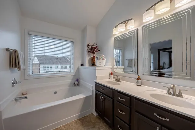 a bathroom with a double vanity sink a mirror and shower