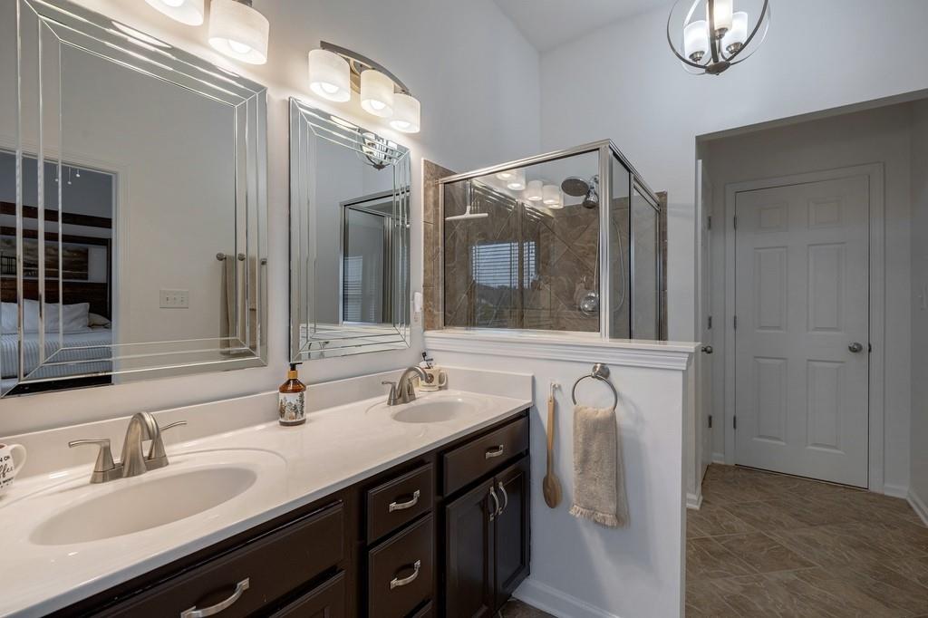 3908 Charleston Market Street Northwest Suwanee, GA 30024 - Photo 30 of 58 a bathroom with a double vanity sink a mirror and shower