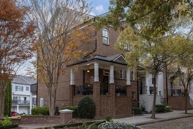 a front view of a house with a tree