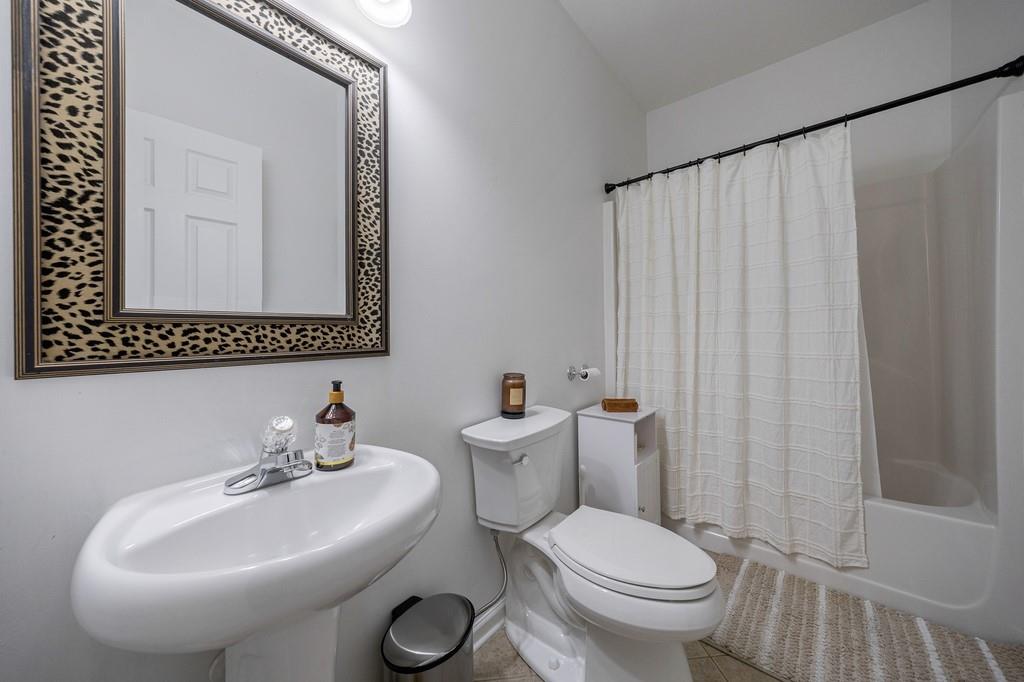 3908 Charleston Market Street Northwest Suwanee, GA 30024 - Photo 40 of 58 a bathroom with a toilet a sink and a mirror