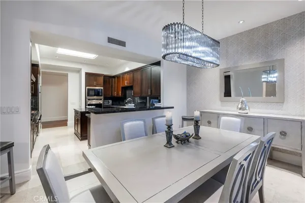 a kitchen with granite countertop a table chairs stove and cabinets