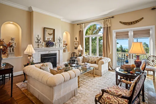 a living room with furniture a fireplace and a large window