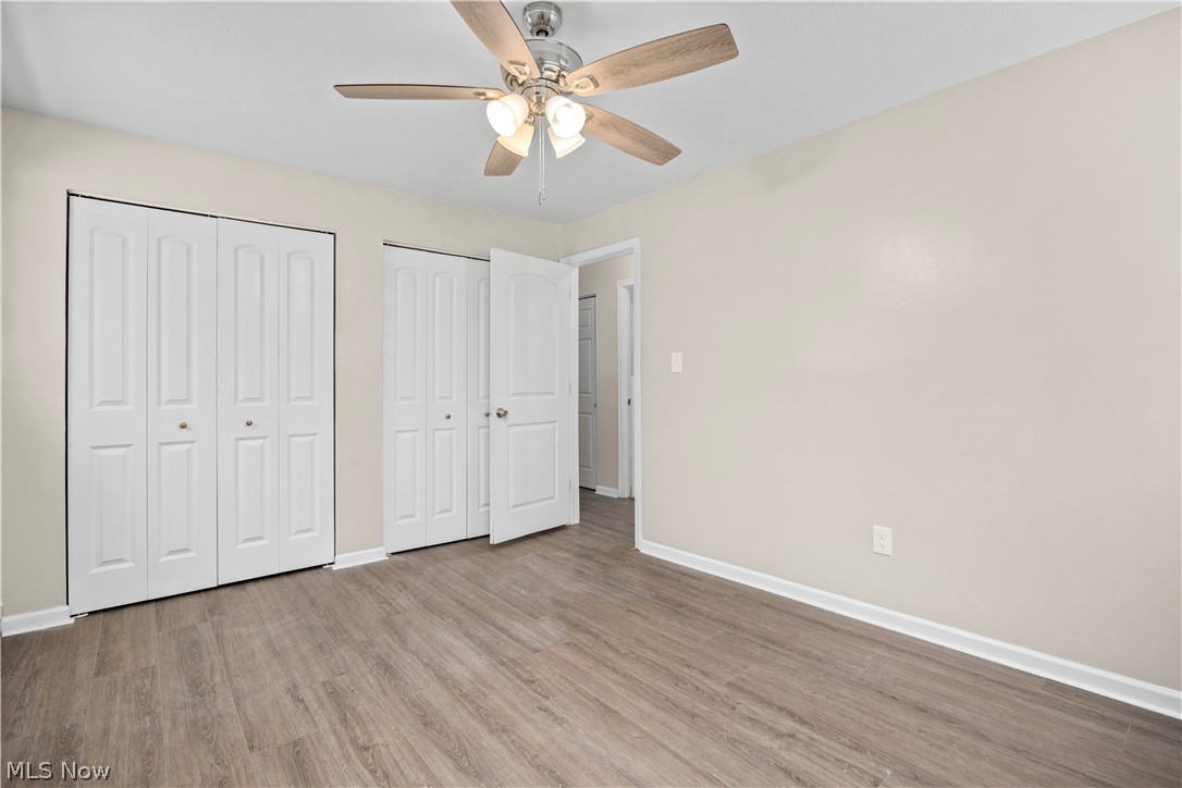 5382 Lee Road, Unit 102 Maple Heights, OH 44137 - Photo 20 of 25 Unfurnished bedroom featuring multiple closets, ceiling fan, and wood finished floors