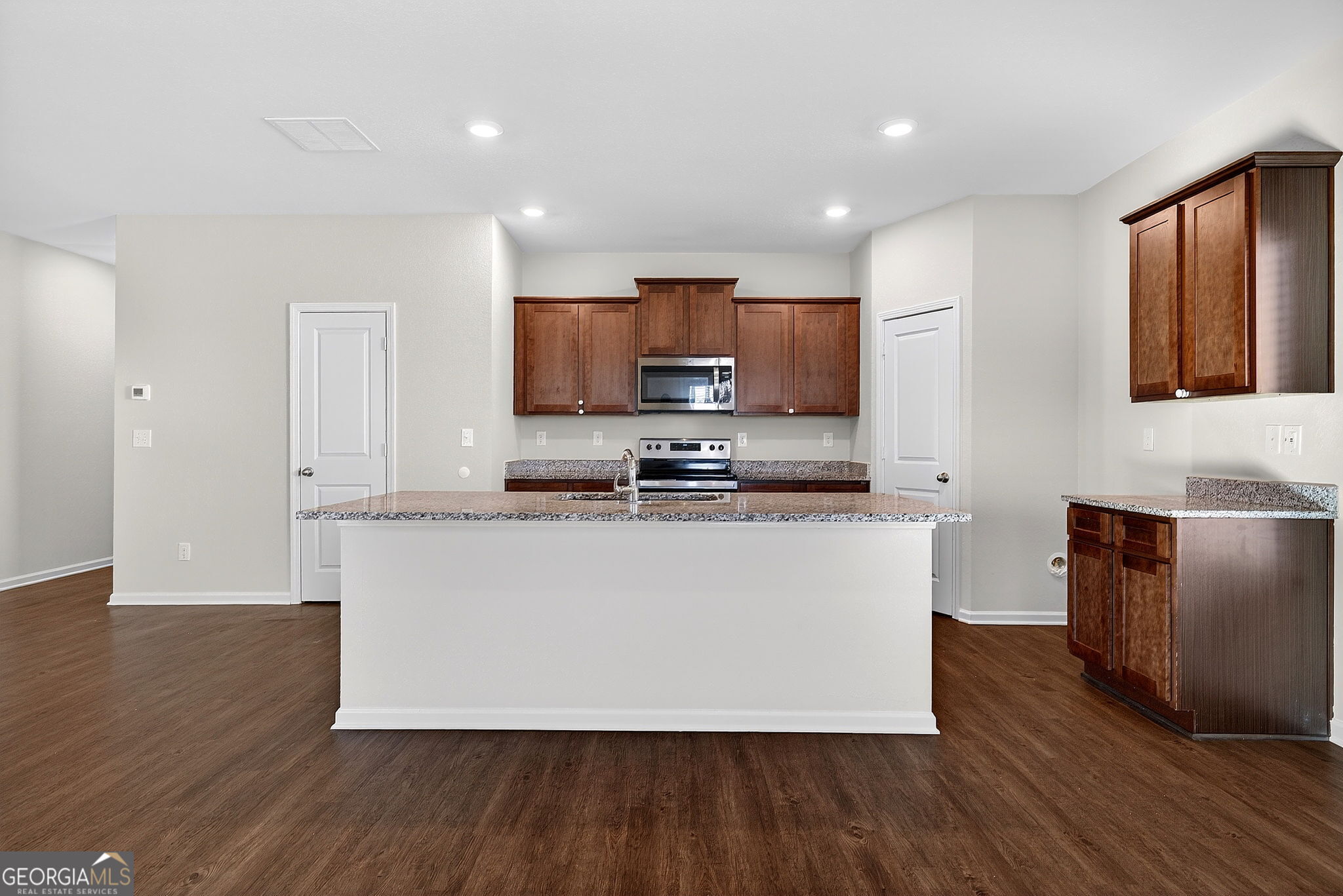 805 Golden Bell Way Villa Rica, GA 30180 - Photo 11 of 51 a living room with stainless steel appliances granite countertop wooden floors a stove a sink and a refrigerator