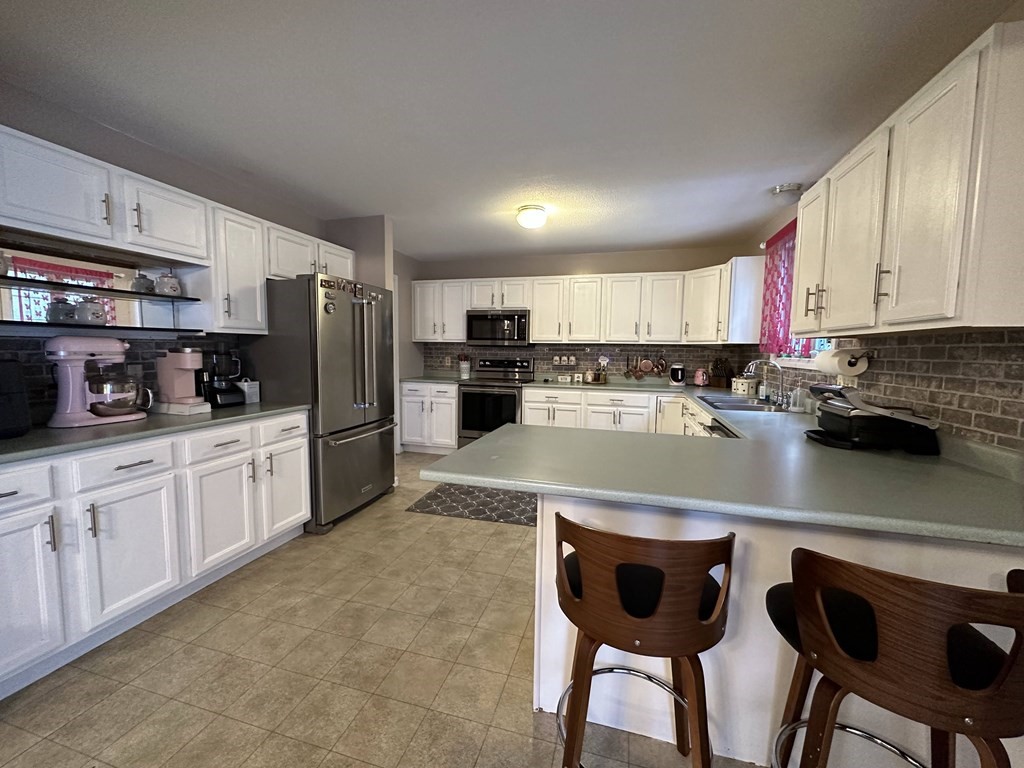 68 Lariviere Drive Chicopee, MA 01020 - Photo 13 of 42 a large kitchen with cabinets chairs and stainless steel appliances