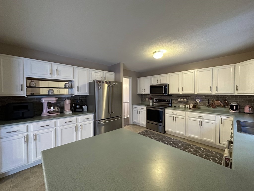 68 Lariviere Drive Chicopee, MA 01020 - Photo 14 of 42 a kitchen with granite countertop a refrigerator and a stove top oven