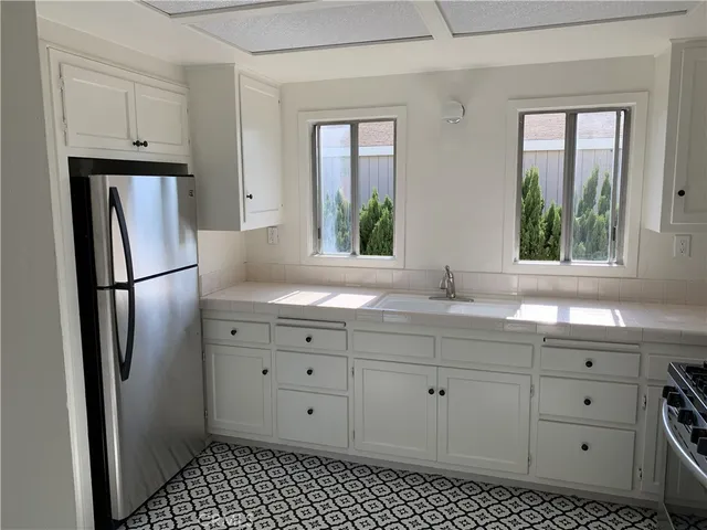 a kitchen with white cabinets and stove
