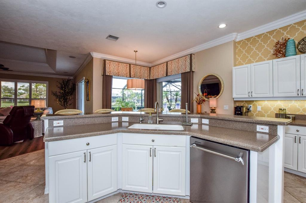 429 Tremingham Way Venice, FL 34293 - Photo 13 of 73 a kitchen with kitchen island granite countertop a sink and white cabinets