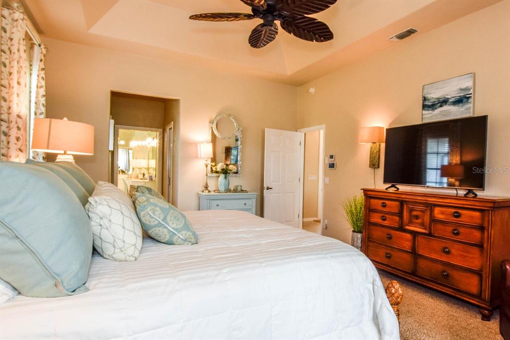 429 Tremingham Way Venice, FL 34293 - Photo 21 of 73 a bedroom with a bed and a flat tv screen on dresser