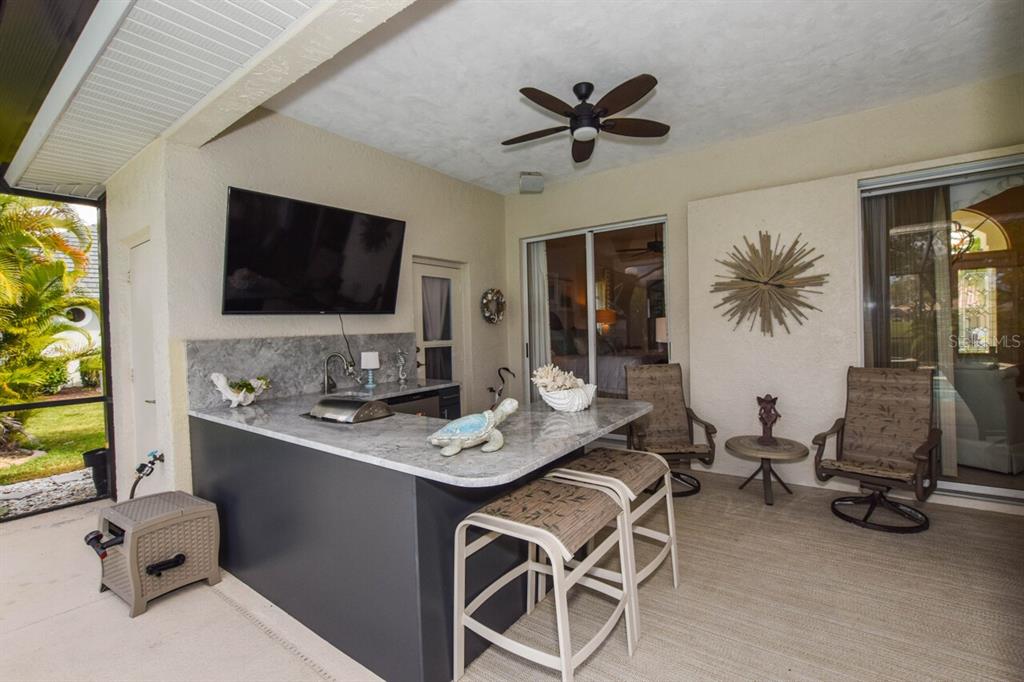 429 Tremingham Way Venice, FL 34293 - Photo 44 of 73 a view of a workspace with furniture and a flat screen tv