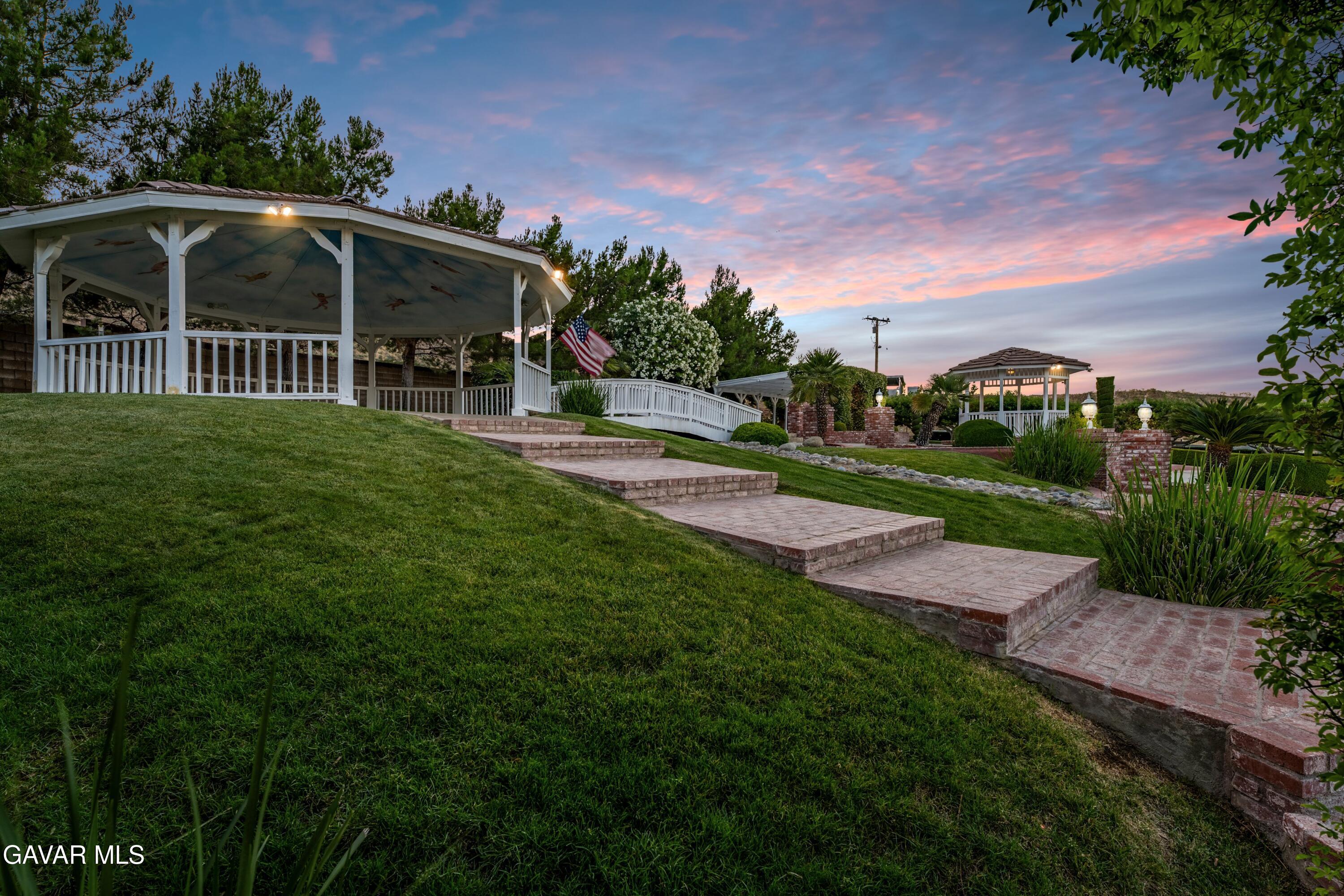 5801 Hacienda Ranch Road Palmdale, CA 93551 - Photo 5 of 69 a view of a wooden house with a yard and potted plants