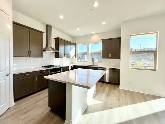 a kitchen with kitchen island granite countertop a sink stove and refrigerator