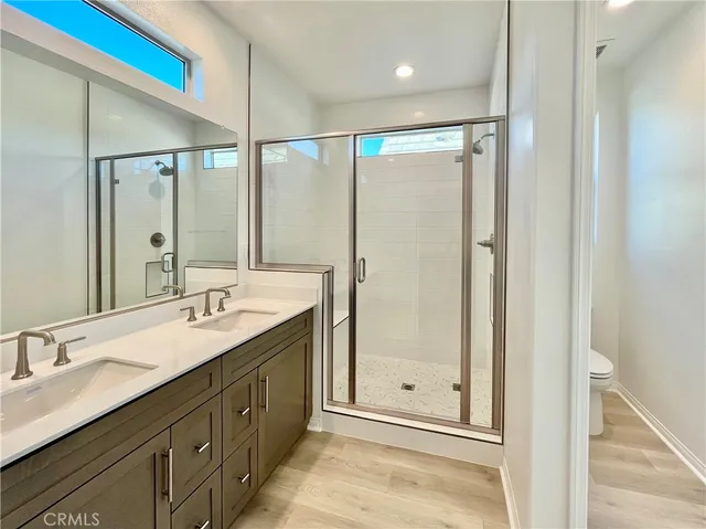 a bathroom with a double vanity sink mirror and shower