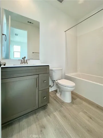 a spacious bathroom with a granite countertop sink a toilet and a mirror