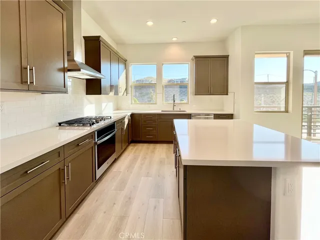 a large kitchen with stainless steel appliances kitchen island granite countertop a stove a sink and a microwave