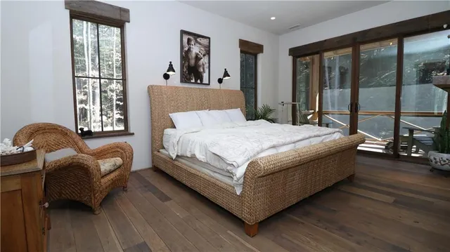 a bedroom with a bed wooden floor and window