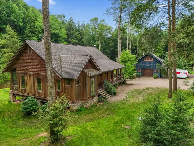 a front view of a house with a yard and trees