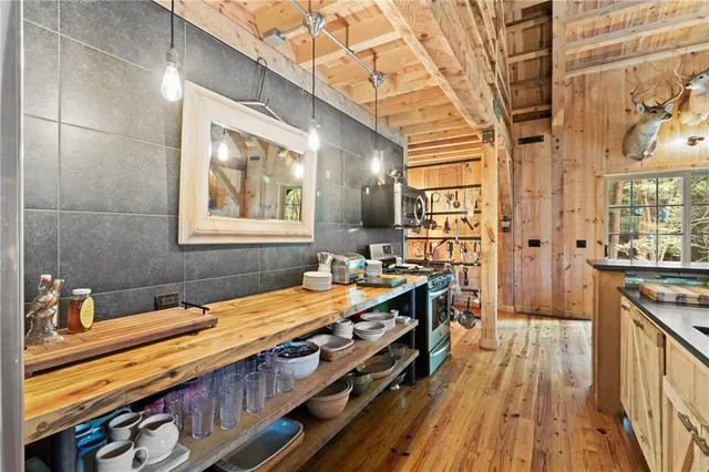 a room with stainless steel appliances a stove window and wooden floor