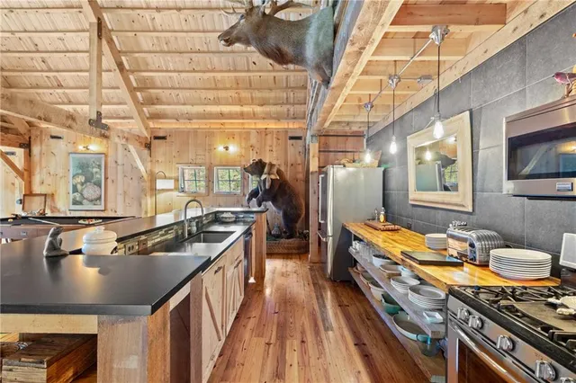 a kitchen with stainless steel appliances granite countertop a stove and a wooden floors