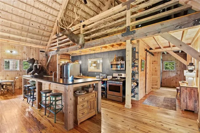 a view of a kitchen with stainless steel appliances granite countertop a stove and wooden cabinets