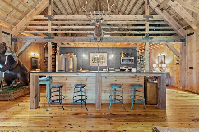 a kitchen with stainless steel appliances kitchen island granite countertop a table and chairs in it
