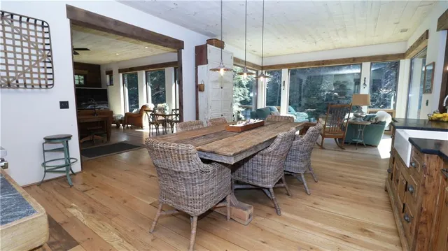 a dining room with furniture large windows and wooden floor