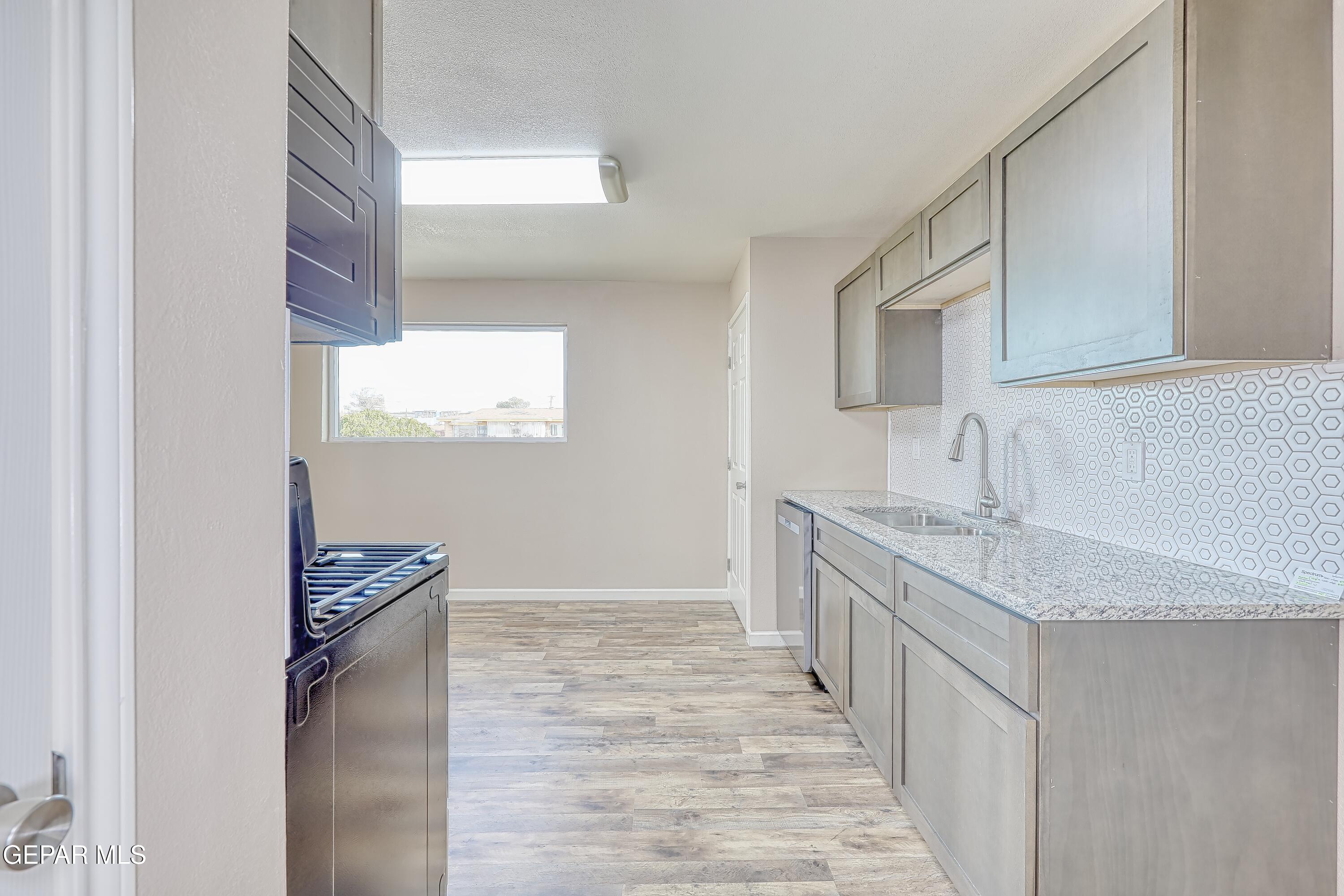 7212 Raton Drive El Paso, TX 79915 - Photo 27 of 44 a kitchen with granite countertop a sink stove and cabinets