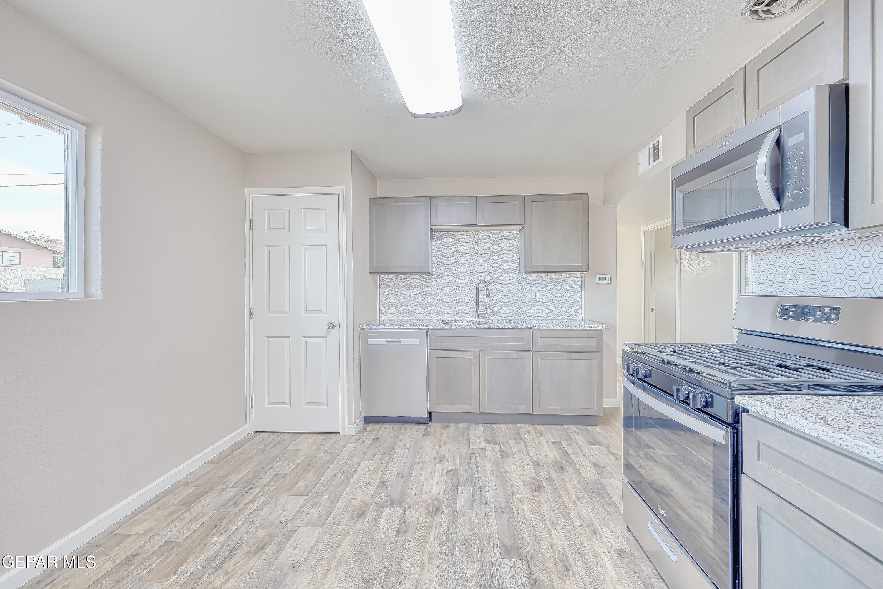 7212 Raton Drive El Paso, TX 79915 - Photo 29 of 44 a kitchen with a stove top oven sink and cabinets