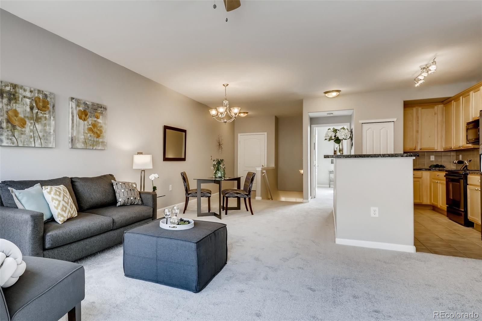5544 Lewis Street, Unit 203 Arvada, CO 80002 - Photo 1 of 38 a living room with furniture and kitchen view