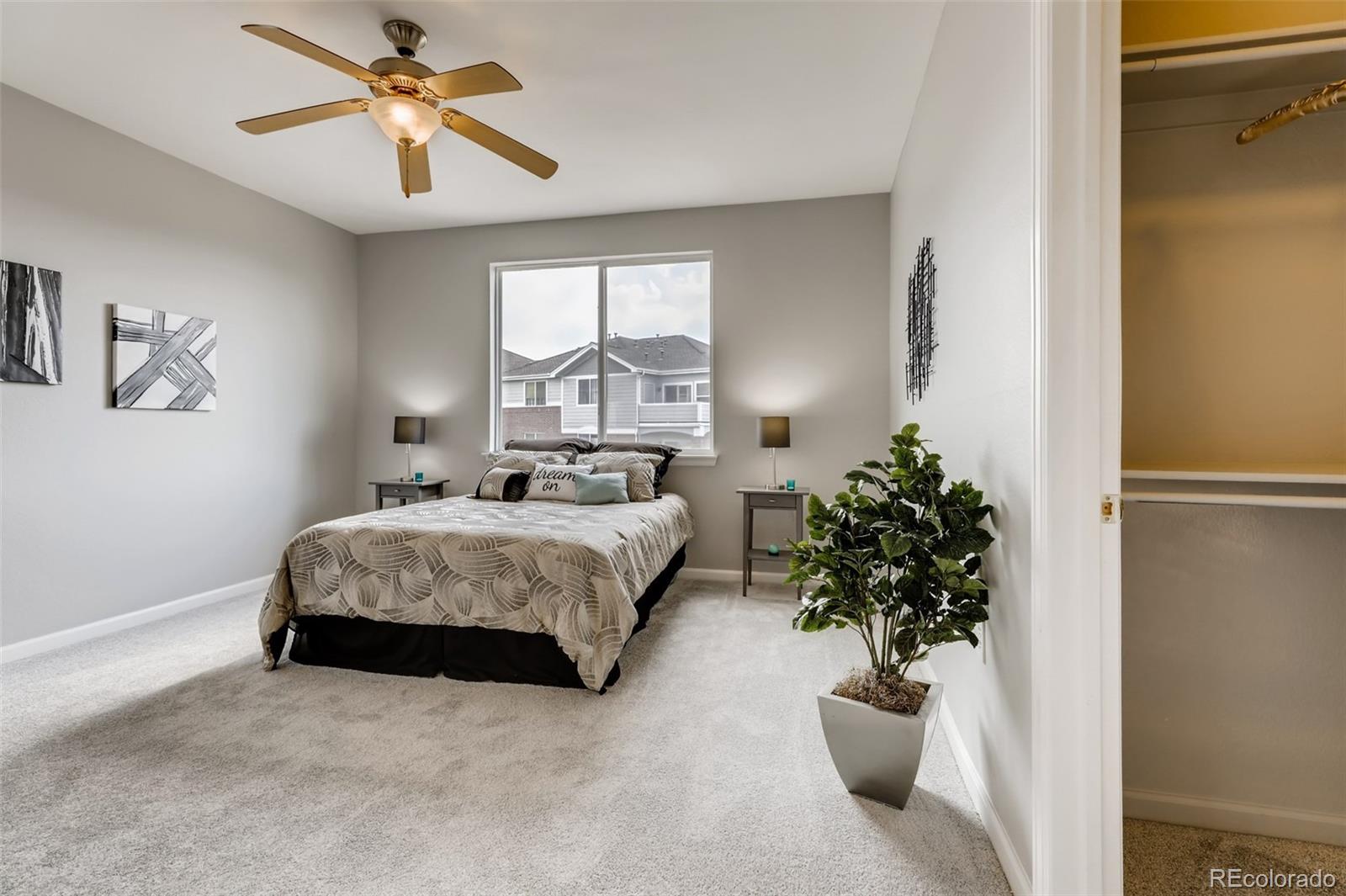 5544 Lewis Street, Unit 203 Arvada, CO 80002 - Photo 18 of 38 a bedroom with a large bed and a chandelier