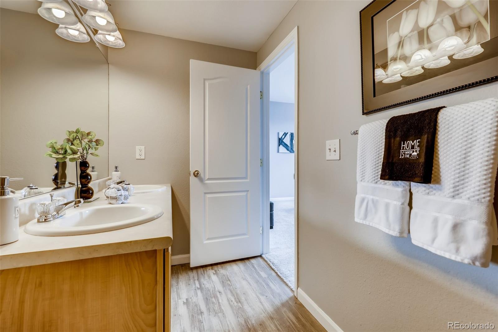 5544 Lewis Street, Unit 203 Arvada, CO 80002 - Photo 19 of 38 a bathroom with a sink mirror and vanity