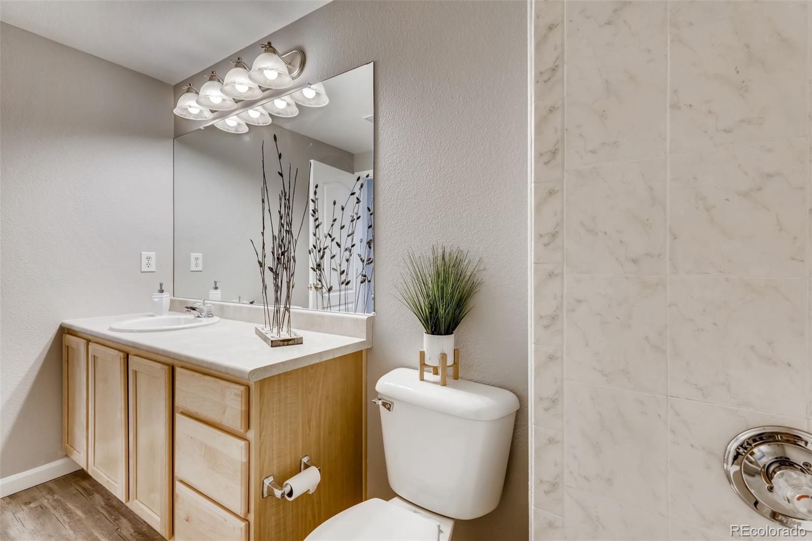 5544 Lewis Street, Unit 203 Arvada, CO 80002 - Photo 24 of 38 a bathroom with a toilet a sink and mirror