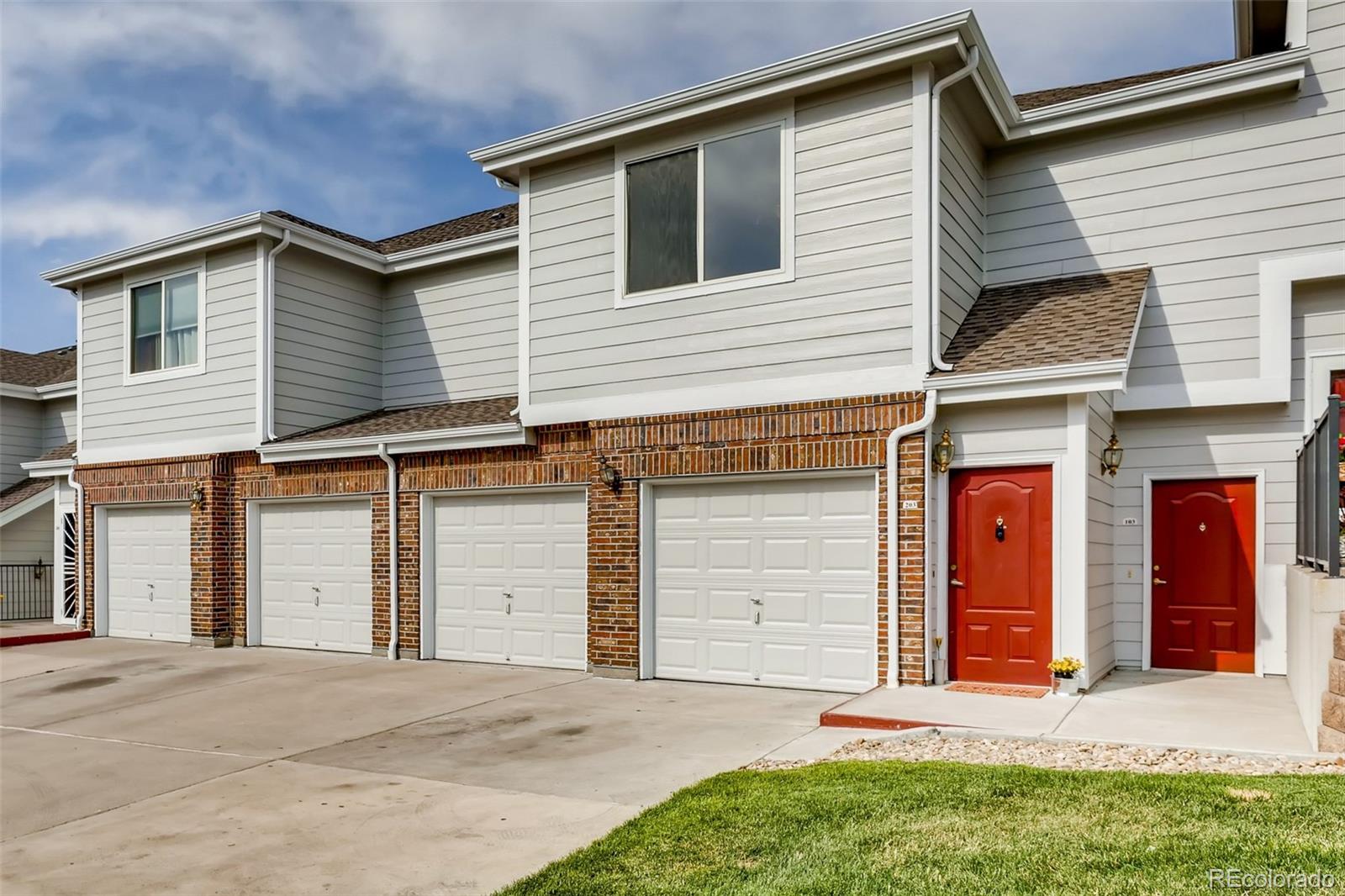 5544 Lewis Street, Unit 203 Arvada, CO 80002 - Photo 27 of 38 a front view of a house with a yard and garage
