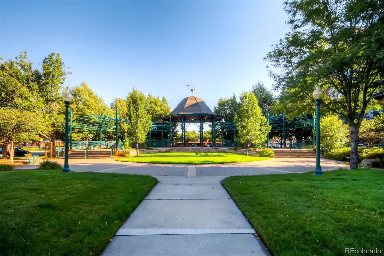 5544 Lewis Street, Unit 203 Arvada, CO 80002 - Photo 34 of 38 a view of swimming pool with lawn chairs and large trees
