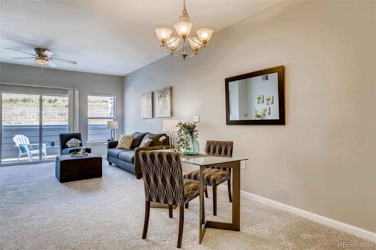 5544 Lewis Street, Unit 203 Arvada, CO 80002 - Photo 8 of 38 a view of a dining room with furniture a chandelier and a window