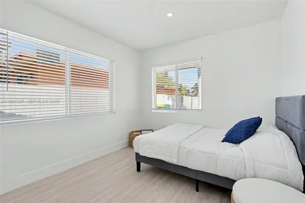 a kitchen with stainless steel appliances granite countertop a refrigerator a oven and white cabinets with wooden floor