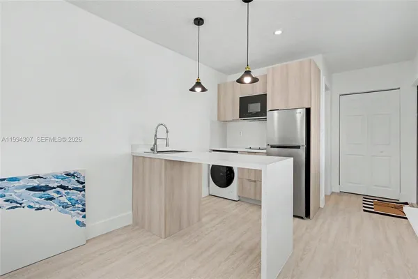 a kitchen with stainless steel appliances kitchen island granite countertop a sink a stove and white wooden cabinets