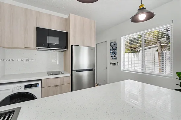 a kitchen with stainless steel appliances a refrigerator a stove a sink and a microwave