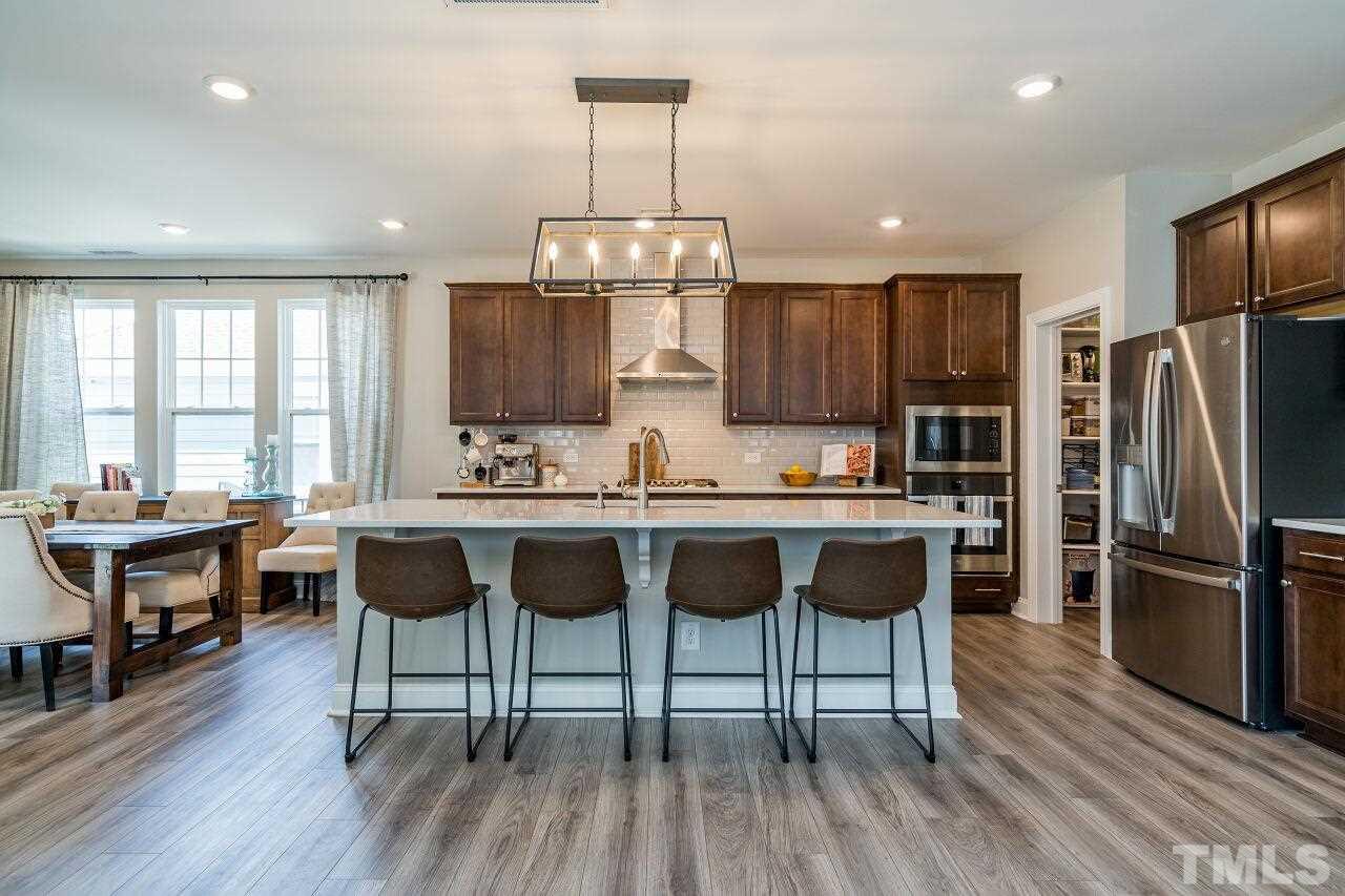 5220 Beckom Street Raleigh, NC 27616 - Photo 11 of 30 Quartz counters, stainless appliances and the tile back splash are great features. The oversized island is perfect for prepping dishes or entertaining.