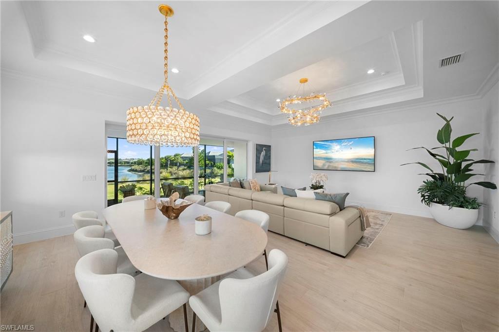 8923 Gustavia Court Naples, FL 34113 - Photo 11 of 50 a living room with furniture a chandelier and a large mirror