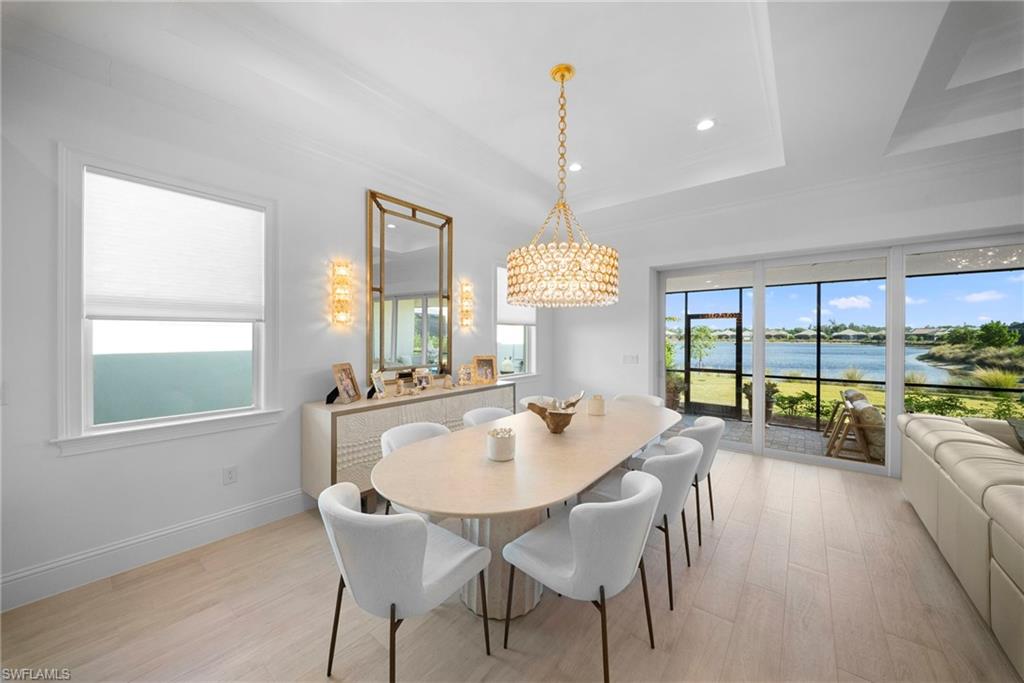 8923 Gustavia Court Naples, FL 34113 - Photo 13 of 50 a view of a dining room and livingroom with furniture wooden floor a chandelier