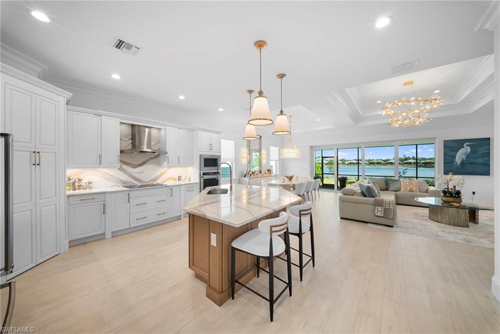 8923 Gustavia Court Naples, FL 34113 - Photo 16 of 50 a kitchen with stainless steel appliances kitchen island granite countertop a sink and cabinets