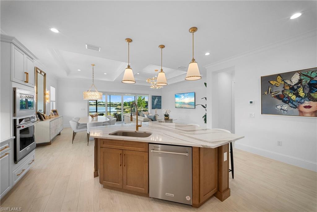 8923 Gustavia Court Naples, FL 34113 - Photo 19 of 50 a dining hall with stainless steel appliances kitchen island a table and chairs in it