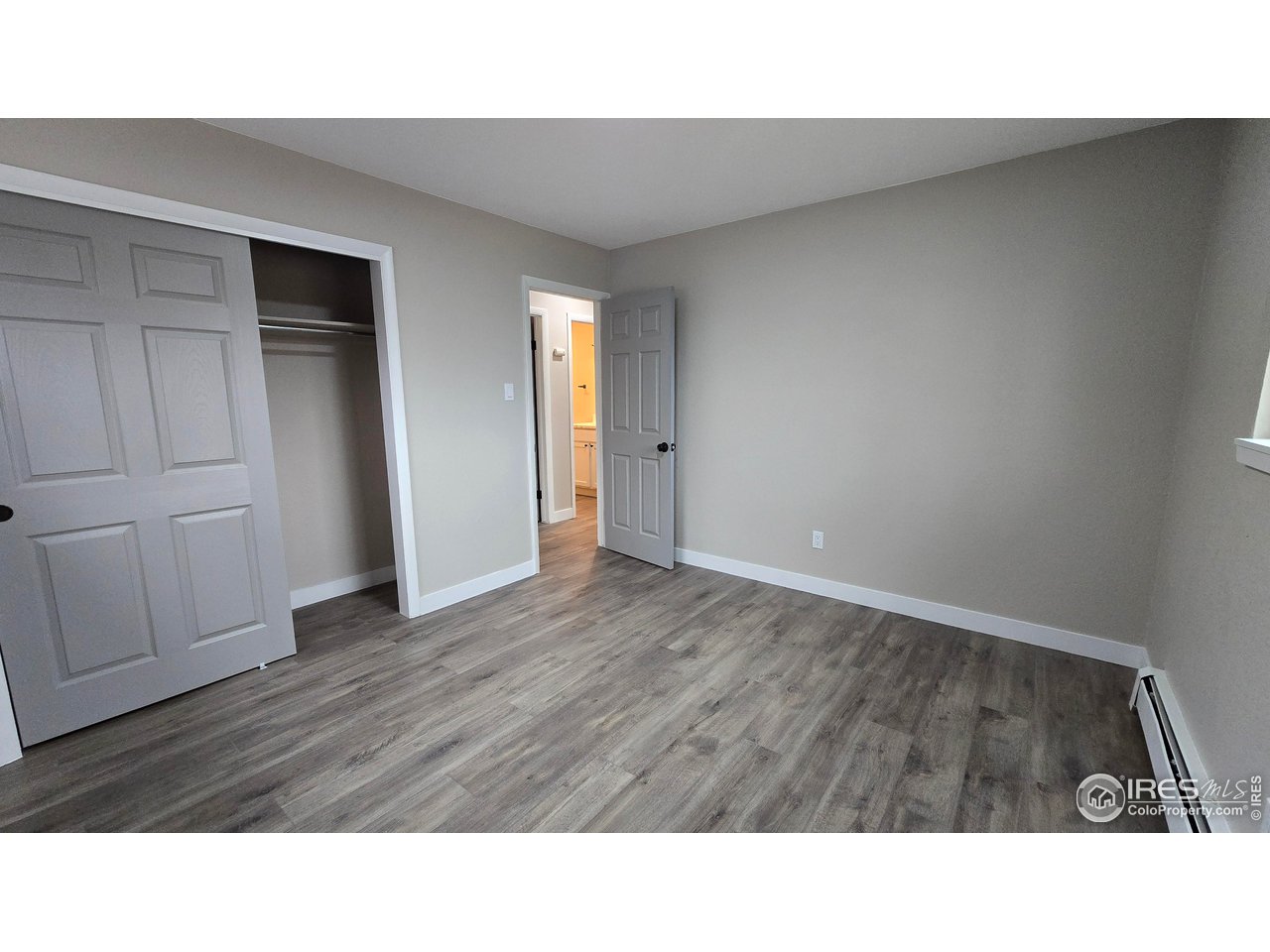 1312 Coolidge Street Sterling, CO 80751 - Photo 23 of 37 SECOND BEDROOM TAKEN BETWEEN THE 2 WINDOWS LOOKING TO HALLWQAY, YOU CAN SEE THE BATHROOM WITH THE BRIGHT LIGHT ON